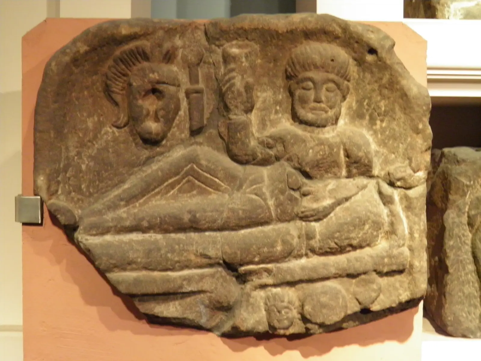 Fragment of a Roman tombstone showing two figures at a funeral banquet.